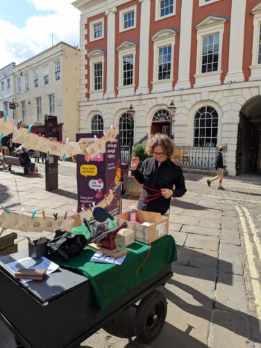 Photo of Stephen in central York with a adana printing press on a cart.