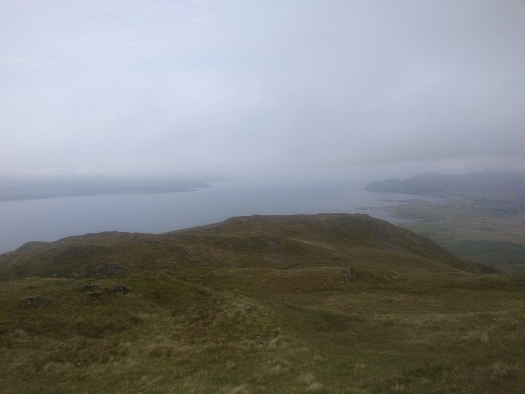 Hills in the mist with the sea beyond them