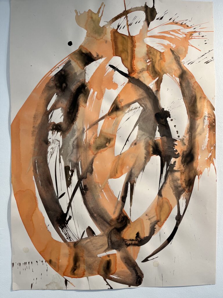 Thick roughly circular strokes of orange and black ink on white paper